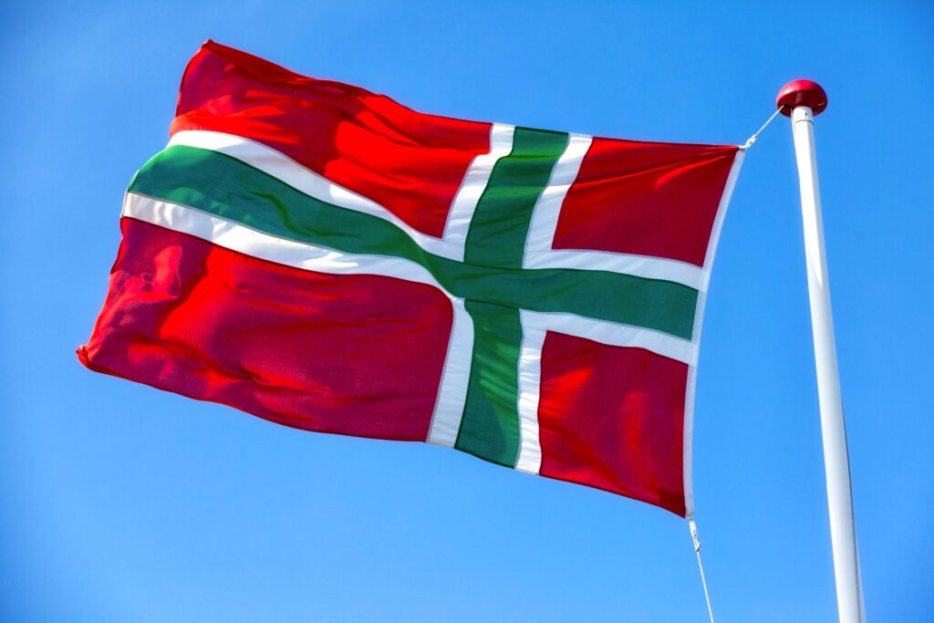Bornholm-Flagge am Mast: rotes Tuch mit grünem Kreuz in weißer Umrandung