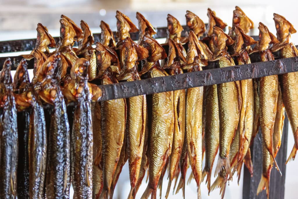 Goldbraune Räucherheringe auf Stangen in der Räucherei in Hasle auf Bornholm