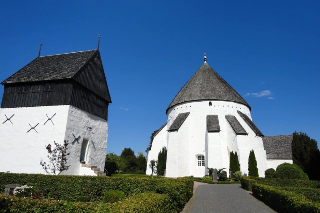 Weiße Rundkirche von Østerlars und Glockenturm mit schwarzer Spitze