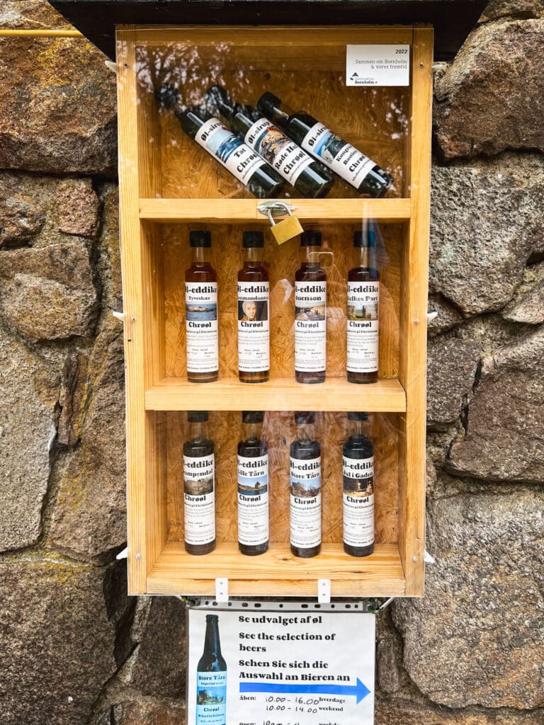 Holzvitrine mit Flaschen von Bier aus der Region auf einer Steinmauer