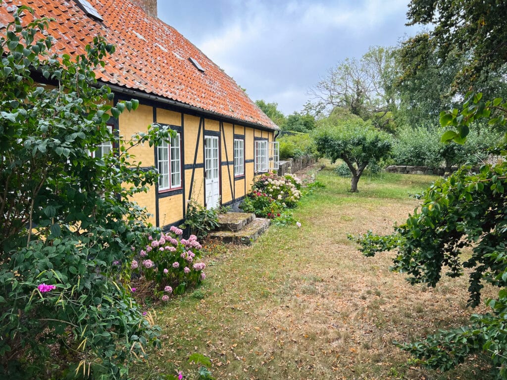 Gelbes Fachwerkhaus, Hortensien und kleine Obstbäume im Garten
