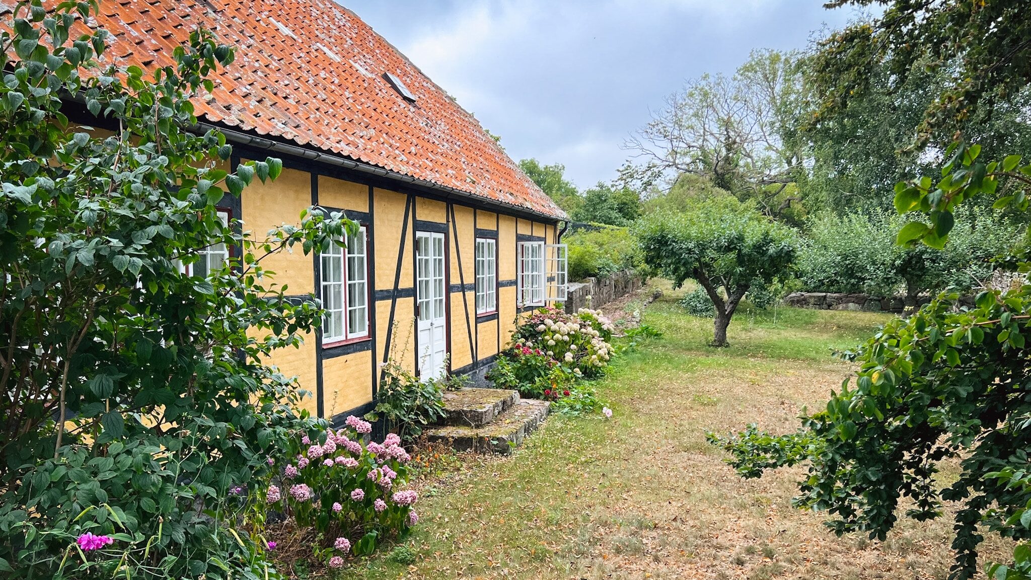 Gelbes Fachwerkhaus mit rotem Dach und Garten auf Christiansø
