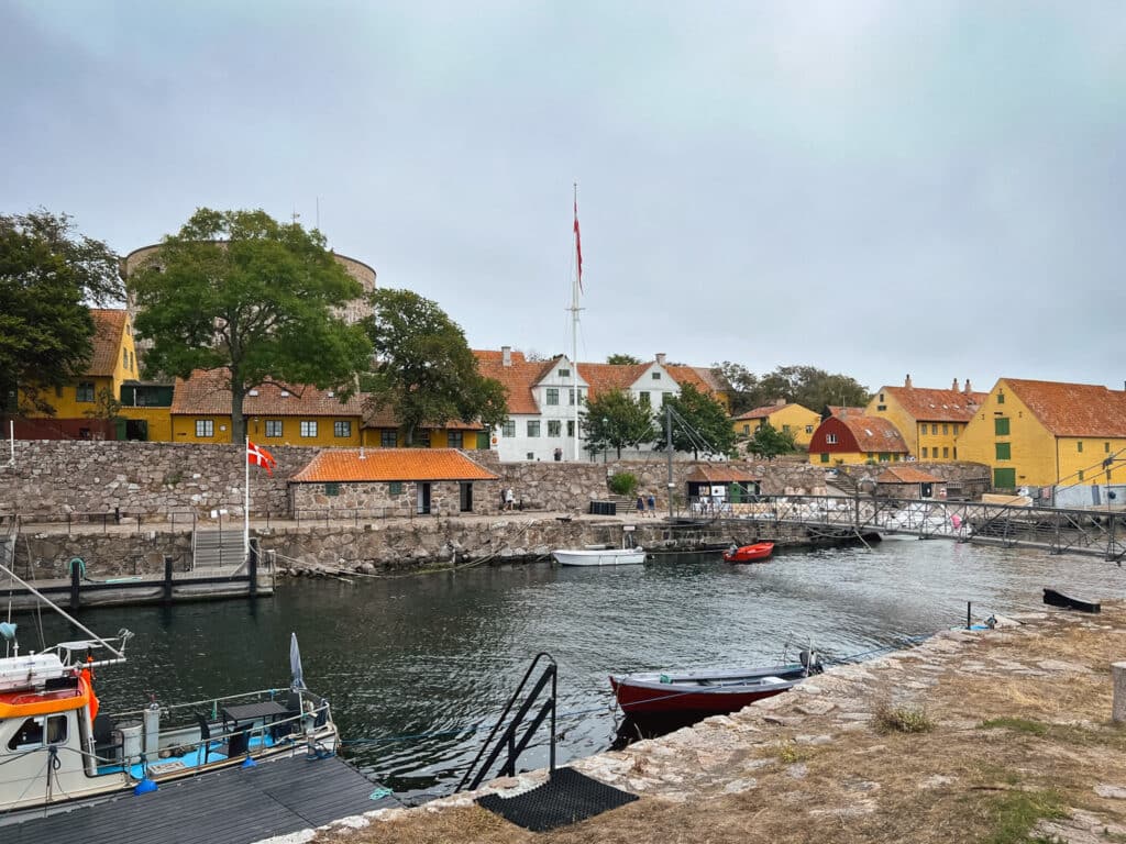 Hafen zwischen den Inseln mit Booten, dänischer Flagge und gelben Häusern