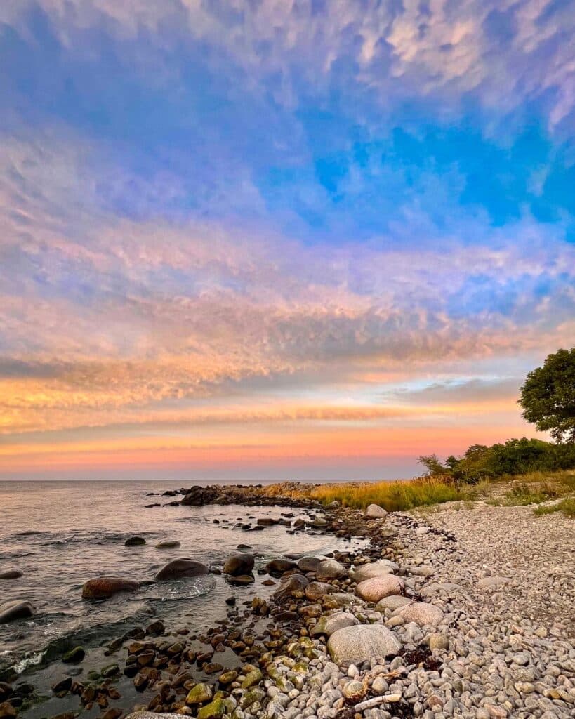 Steinstrand Kobbeå unter rosa-blauem Himmel