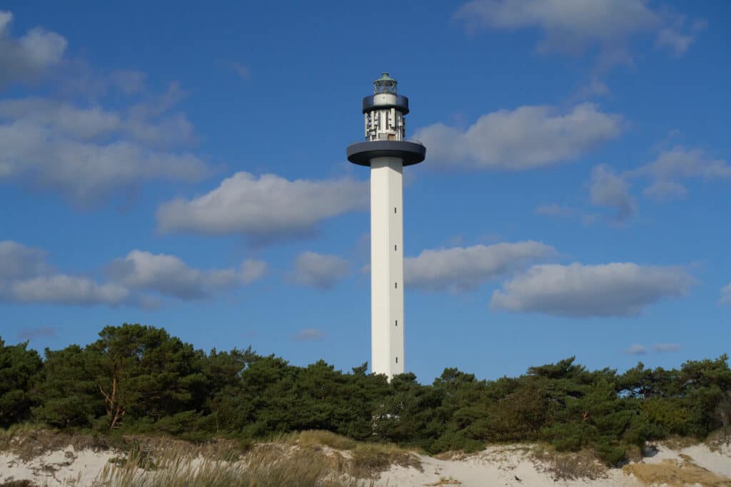 Der schlanke weiße Leuchtturm Dueodde Fyr über einem Kiefernwald
