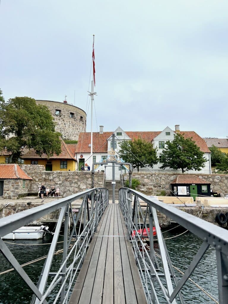 Fußgängerbrücke und Hafen, im Hintergrund der Turm des Leuchtturms Christiansø Fyr