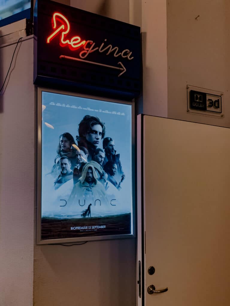 Leuchtschrift Regina mit Pfeil und Filmplakat von Dune im Kino in Ystad
