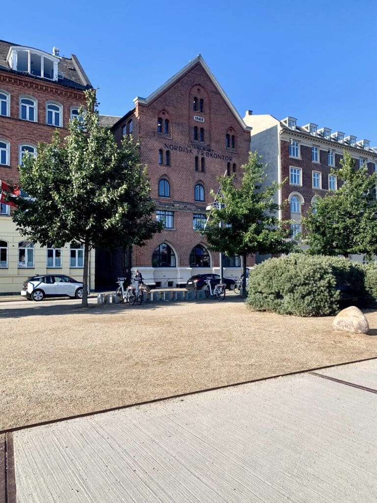 Backsteingebäude mit Giebel und Bäume an einem Platz in Kopenhagen