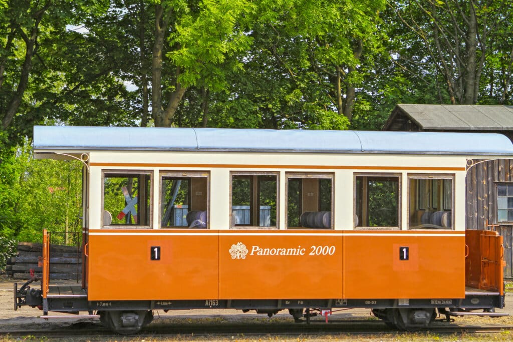 Orange-weißer Wagen einer Schmalspurbahn