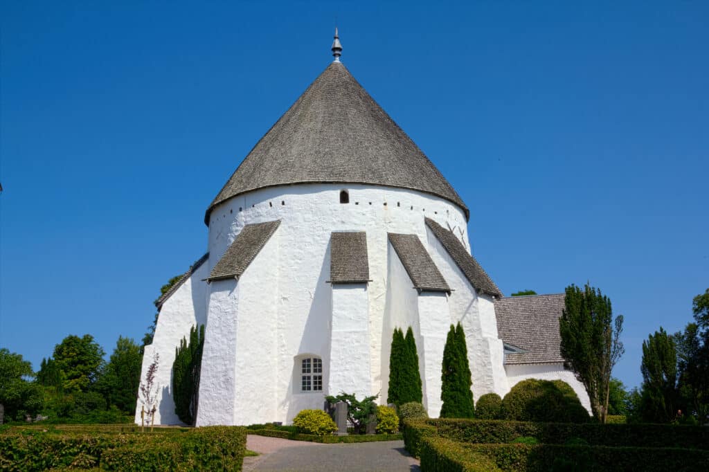Weiße Rundkirche von Østerlars mit Kegeldach und Stützpfeilern