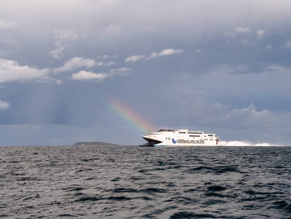 Schnellfähre von Bornholmslinjen auf dem Meer, im Hintergrund ein Regenbogen