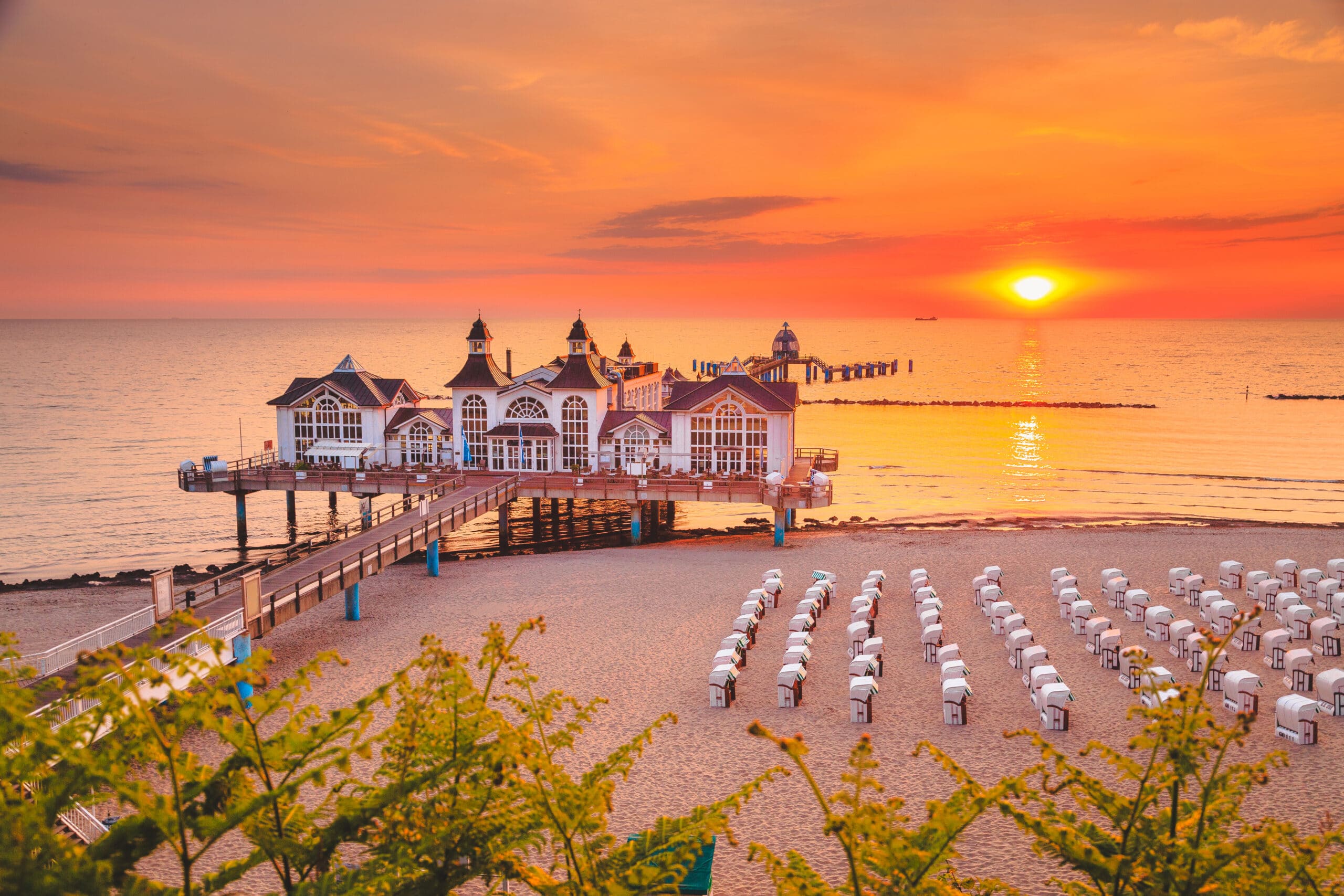 Seebrücke in Sellin auf Rügen bei Sonnenuntergang, am Strand Strandkörbe
