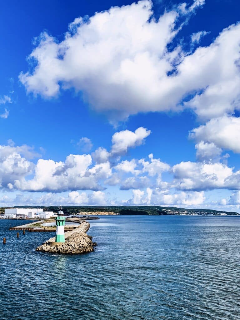 Leuchtturm auf der Mole und Rügens Küste, gesehen von der Fähre nach Bornholm