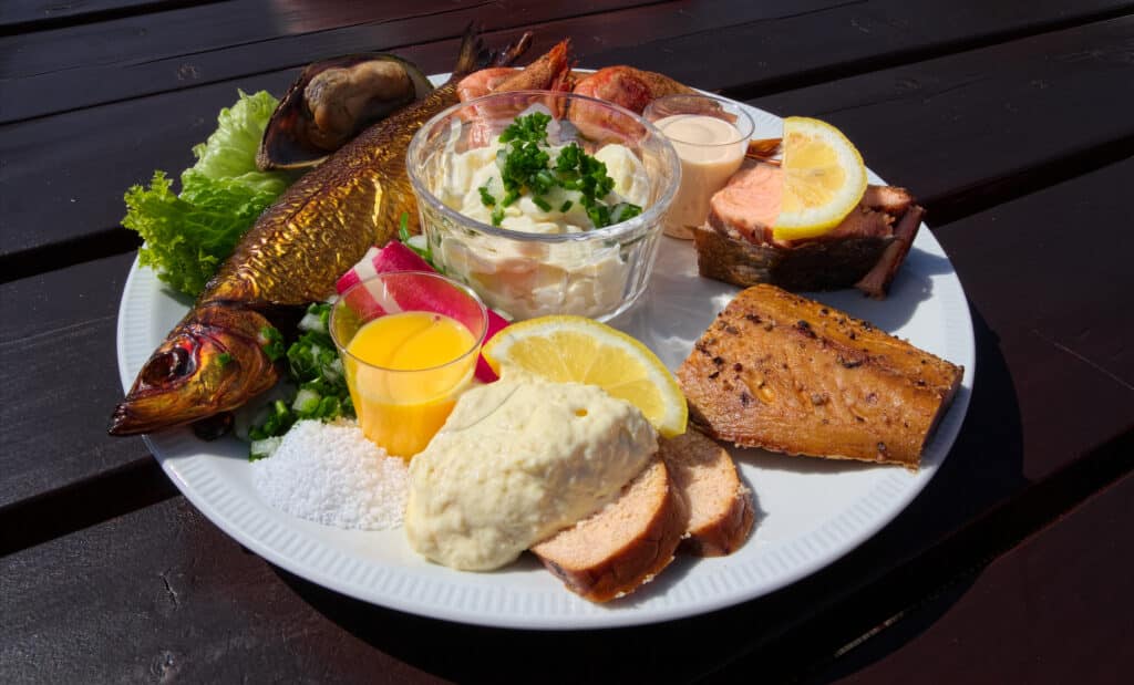 Teller mit Räucherfisch, Eigelb, Salat und Zitrone