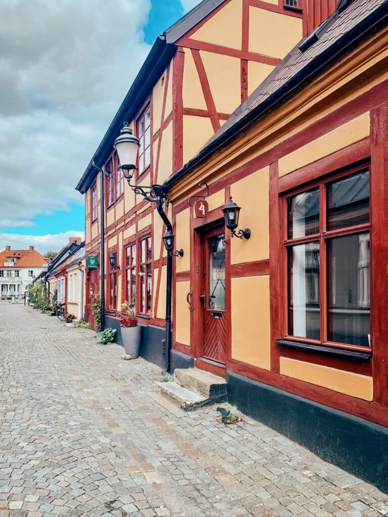 Gelb-rotes Fachwerkhaus an einer Kopfsteinpflasterstraße in Ystad