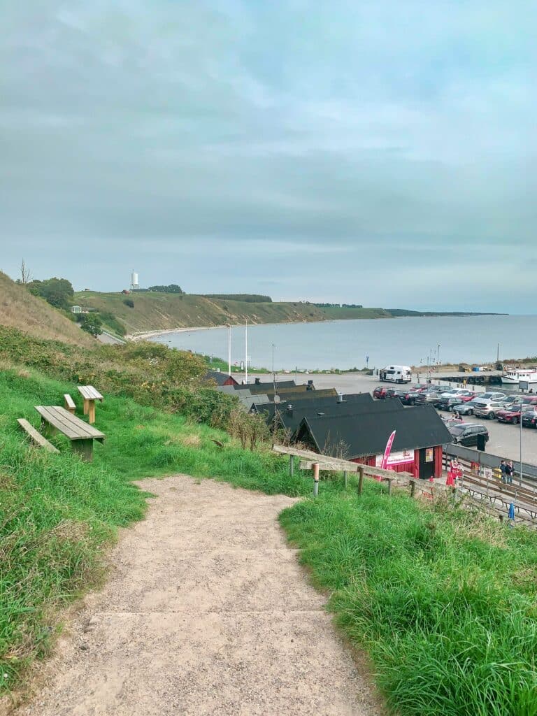 Weg vom Hügel hinunter zum Hafen von Kåseberga, im Hintergrund die Küste