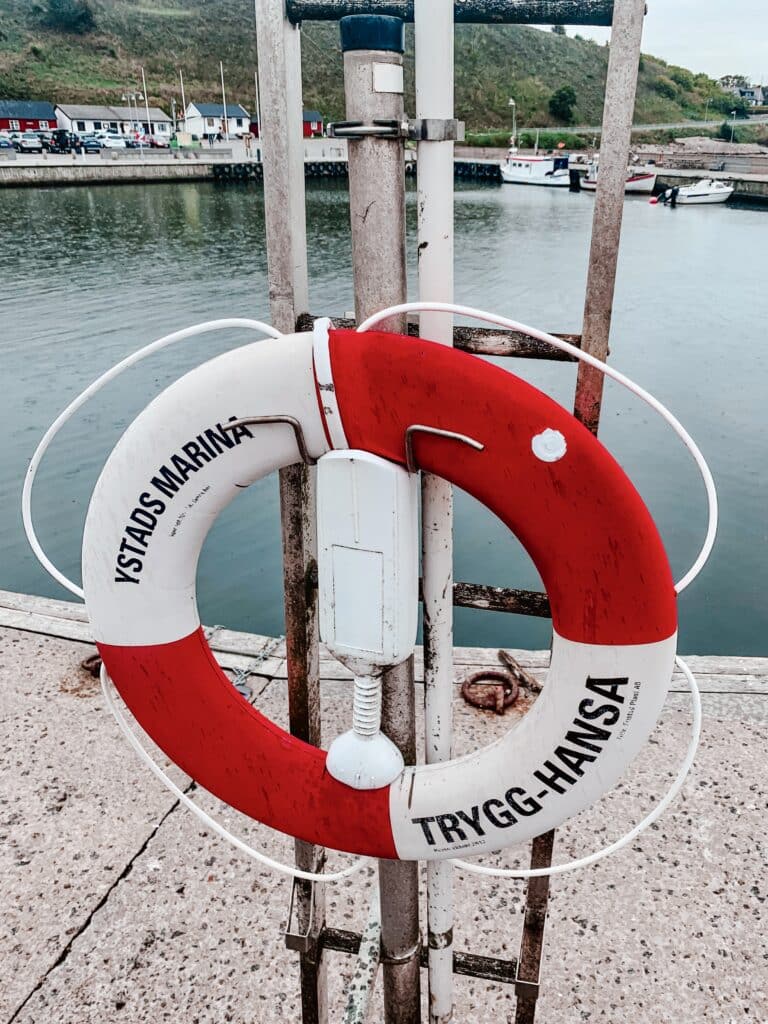 Rot-weißer Rettungsring am Kai im Hafen von Kåseberga