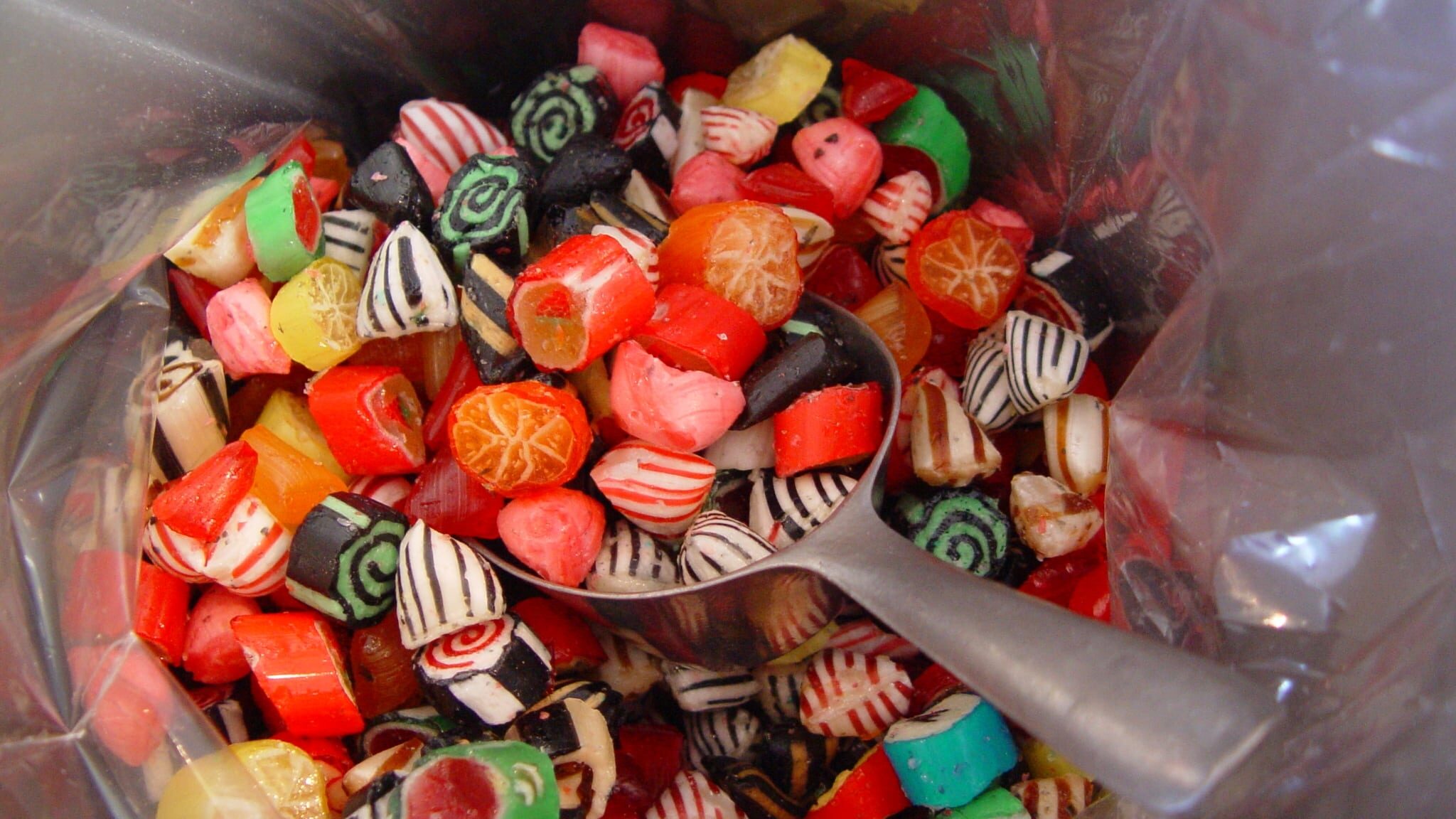 Bunte Hartbonbons in einer Tüte mit einer Metallschaufel