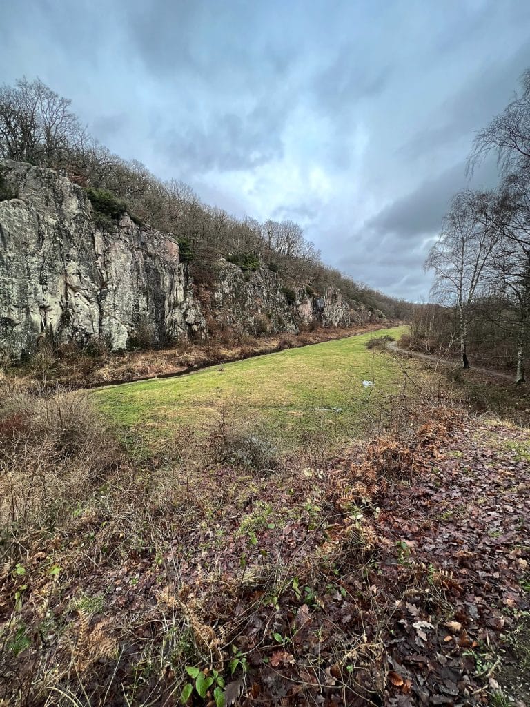 Ekkodalen im Winter: Felswand der Schlucht und grüne Wiese im Talgrund