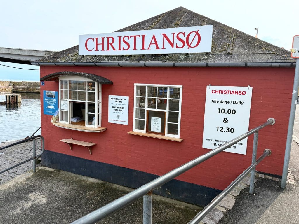 Rotes Häuschen mit der Aufschrift Christiansø, der Ticketschalter für die Überfahrt im Hafen von Gudhjem