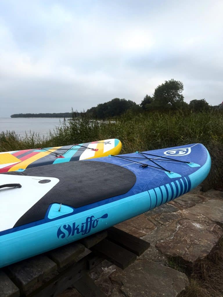 Zwei aufblasbare SUP-Boards auf einer Slipanlage aus Stein am Meer an einem bewölkten Abend