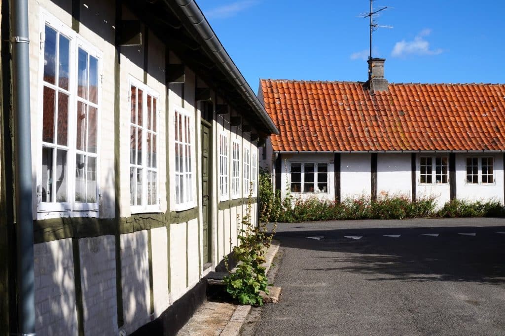 Weißes Fachwerkhaus und niedriges Haus mit rotem Ziegeldach in Svaneke