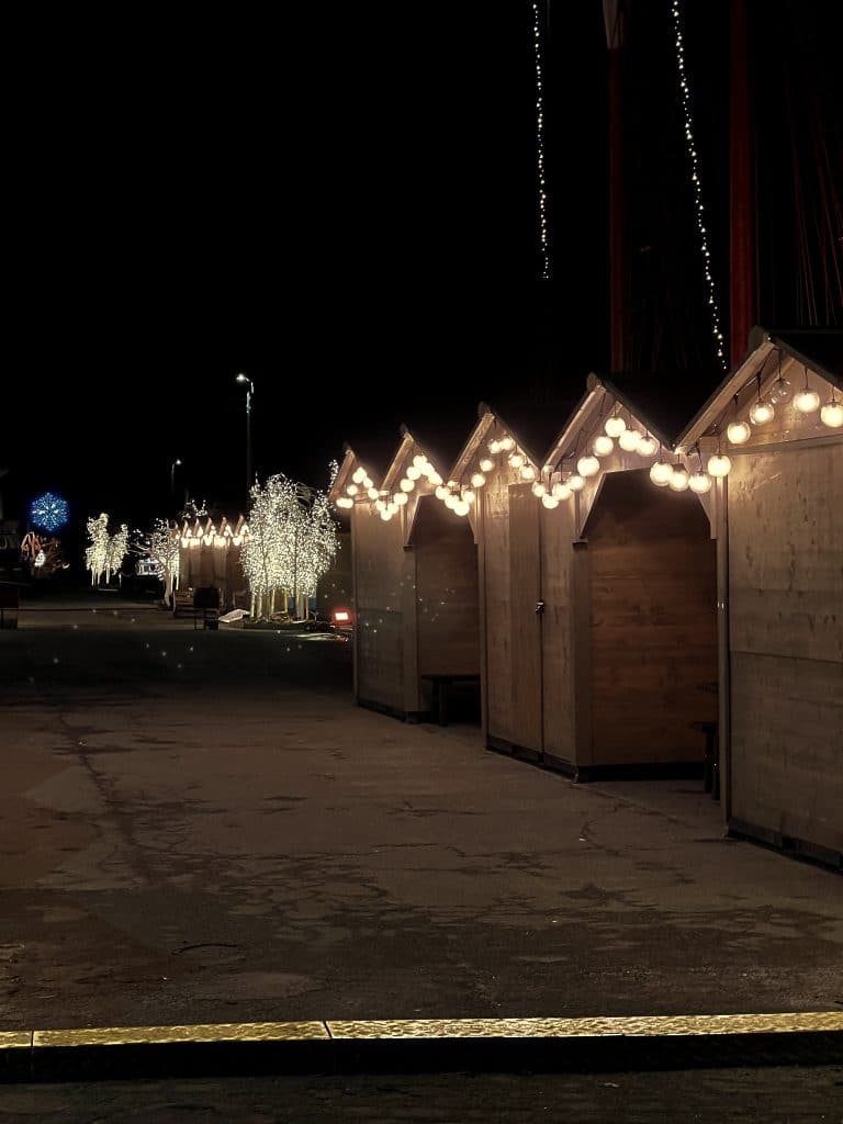 Holzbuden mit Weihnachtsbeleuchtung im Hafen von Nexø bei Nacht