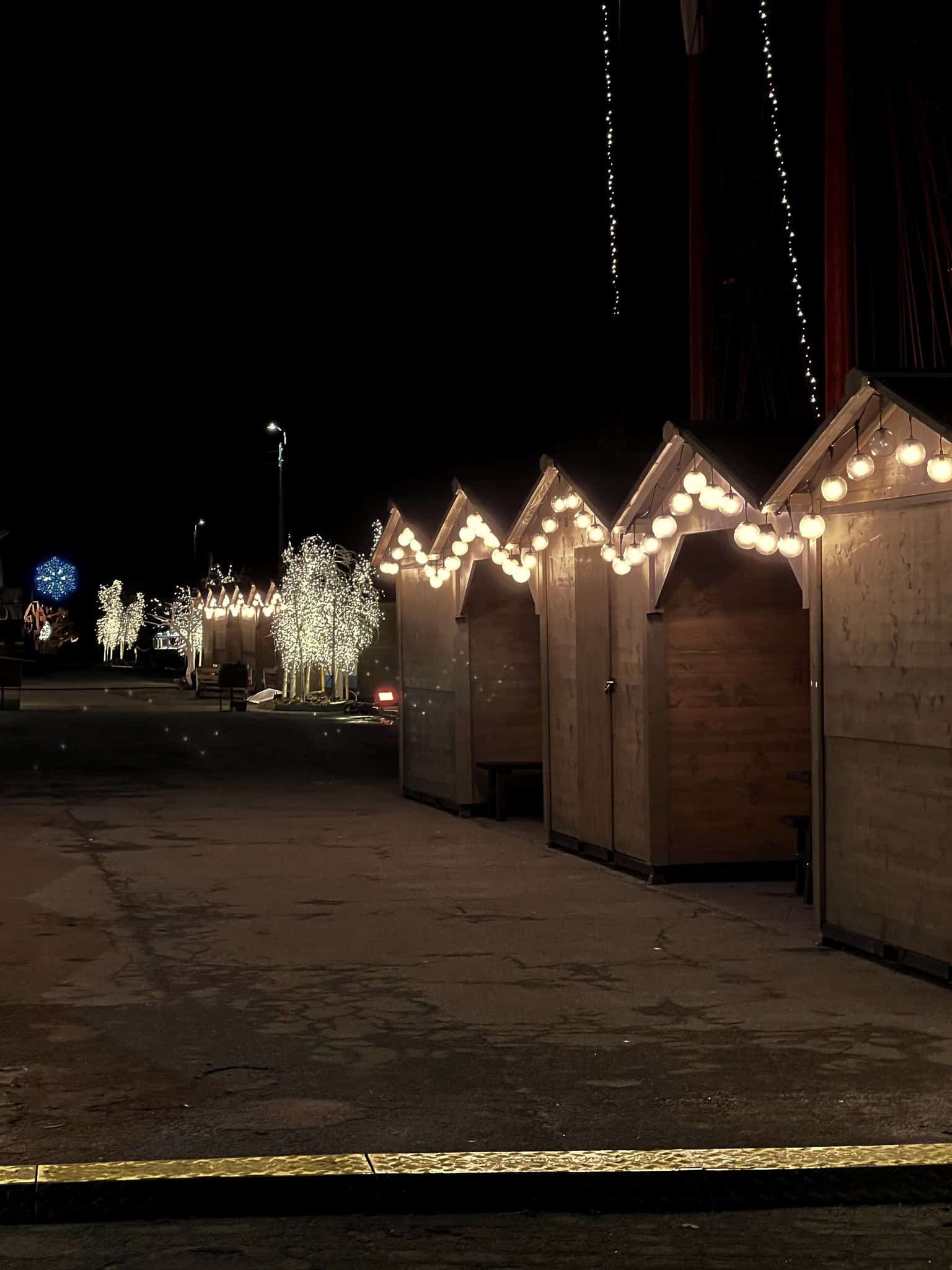 Holzbuden mit Weihnachtsbeleuchtung im Hafen von Nexø bei Nacht