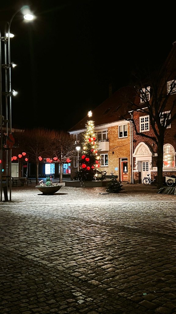 Marktplatz von Nexø bei Nacht mit Weihnachtsbaum und Lichterketten