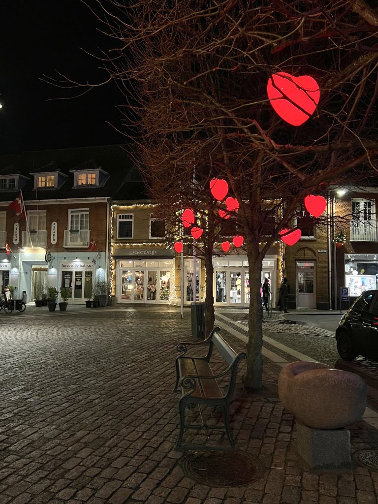 Rot leuchtende Herzen in den Bäumen am Marktplatz von Nexø