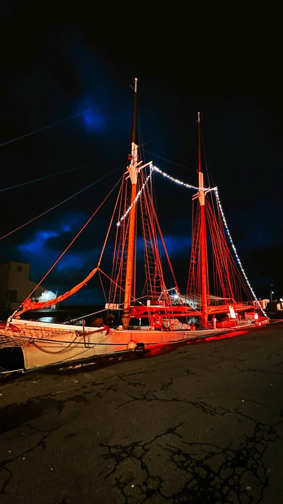 Segelschiff im Hafen von Nexø mit roten Lichterketten